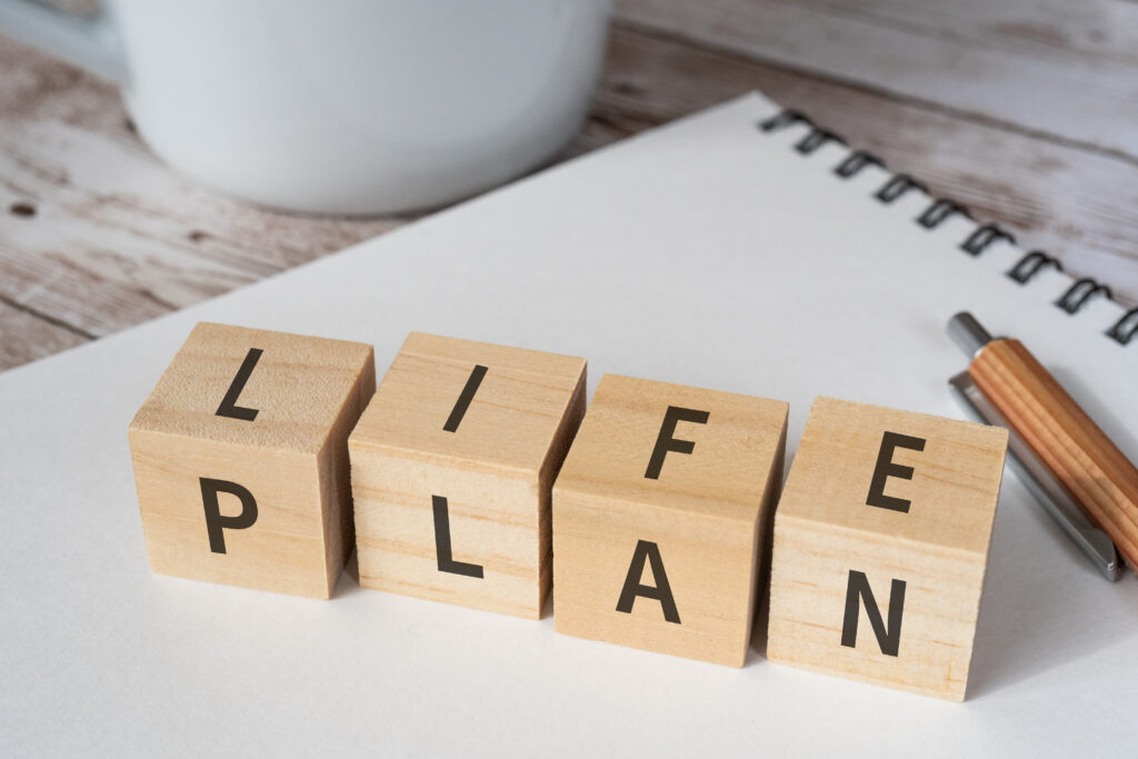 wooden blocks with life plan text concept pen notebook cup