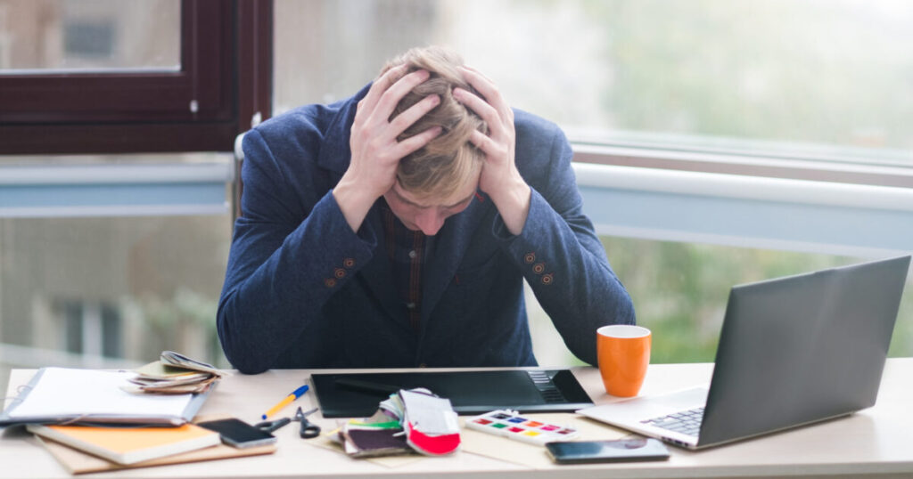 business failure financial crisis problems stress frustration tiredness loss concept worker sitting office holds his head hands scaled e1788944487581