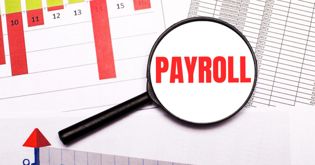 desktop graphs reports magnifying glass with inscription payroll scaled e1788943934823